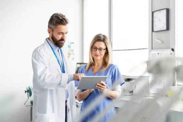 doctor-nurse Home a doctor and nurse in medical scrubs using a tablet to discuss weight loss medicine plans